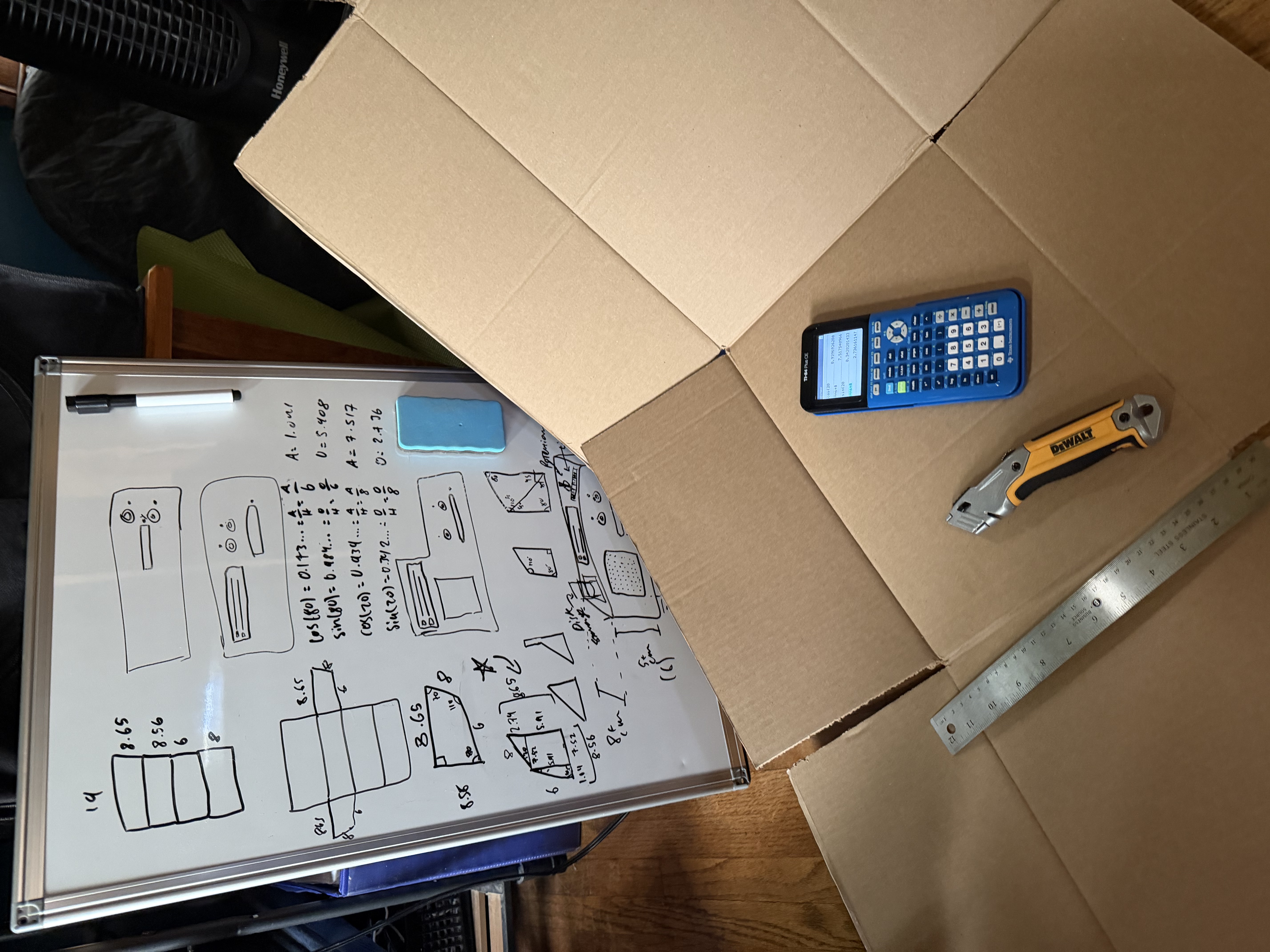 A whiteboard depicting enclosure sketches, cardboard, a calculator, and a box cutter. What more could one need?